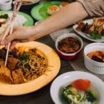 Ręka pał chopsticks po wegańskim ramenu i azjatyckich przekąskach